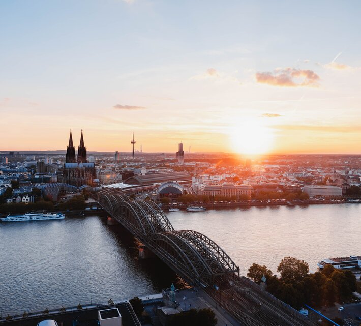 Skyline von Düsseldorf- im Vordergrund der Rhein mit Brücke im Sonnenuntergang | © Unsplash