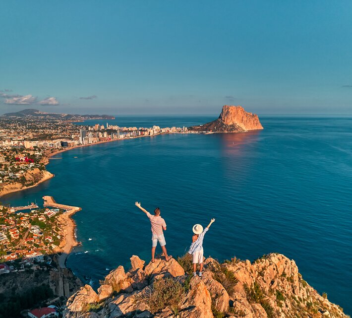 Blick von einem Felsen auf Alicante mit winkendem Parr im Vordergrund | © Envato Elements