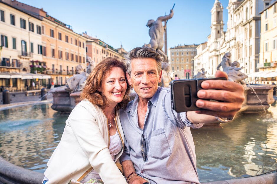 Seniorenpaar vor Brunnen beim Machen eines Selfies | © Envato Elements