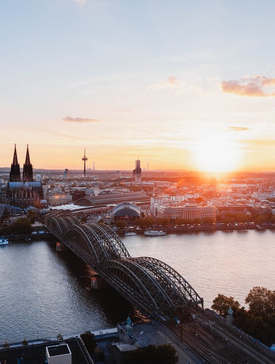 Skyline von Düsseldorf- im Vordergrund der Rhein mit Brücke im Sonnenuntergang | © Unsplash