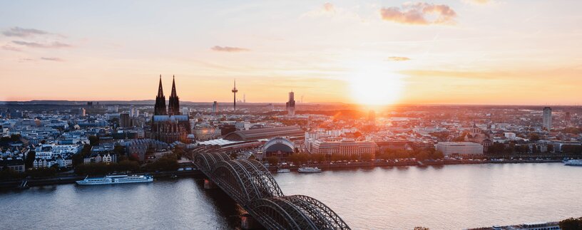 Skyline von Düsseldorf- im Vordergrund der Rhein mit Brücke im Sonnenuntergang | © Unsplash
