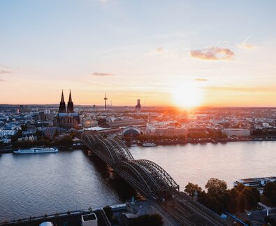 Skyline von Düsseldorf- im Vordergrund der Rhein mit Brücke im Sonnenuntergang | © Unsplash