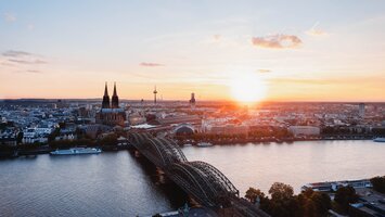 Skyline von Düsseldorf- im Vordergrund der Rhein mit Brücke im Sonnenuntergang | © Unsplash