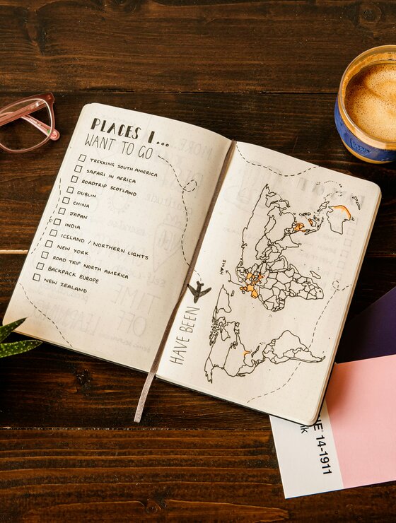 Urlaubsplaner mit To-Do-Liste und Landkarte auf Tisch | © Unsplash