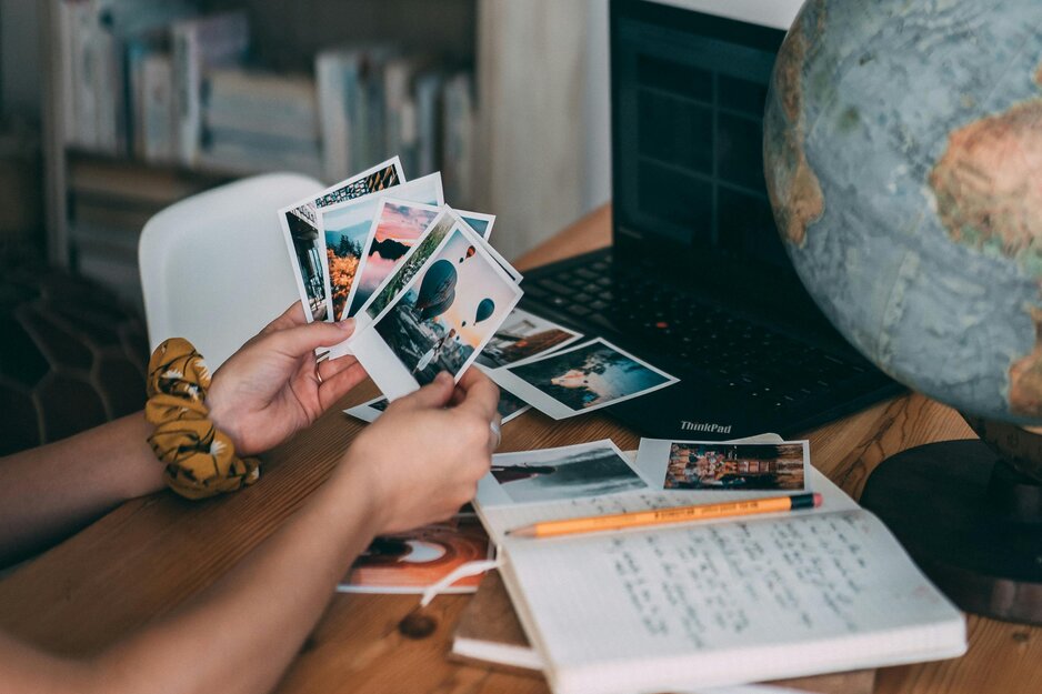 Junge Frau hält Polaroid-Bilder aus dem Urlaub in der Hand | © Pexels
