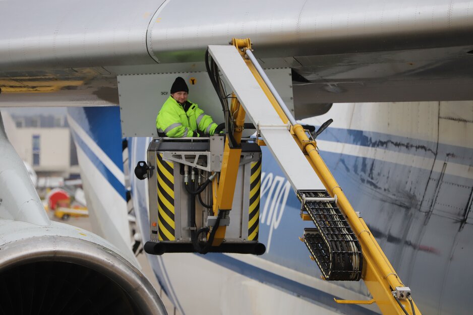 Vorfeldmitarbeiter im Korb des Enteisungsgerätes Eisbär unter einer Tragfläche  | © Linz Airport