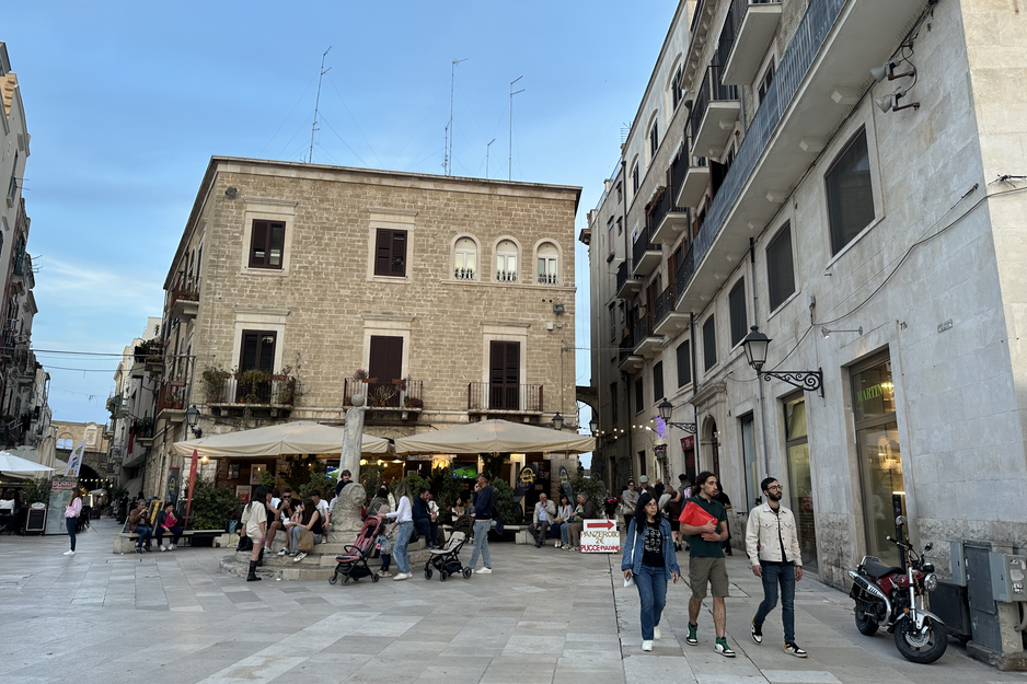 Platz in Bari mit Speiselokalen und im Vordergrund Besucher, die durch die Stadt schlendern | © Linz Airport