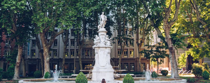 Frau im Rollstuhl vor Brunnen mit Statue | © Carlos Navas Unsplash