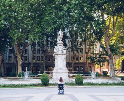 Frau im Rollstuhl vor Brunnen mit Statue | © Carlos Navas Unsplash