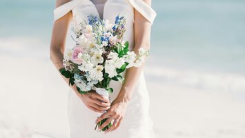 Körpermitte einer Braut in elegantem Kleid mit wunderschönen Blumenstrauß | © Pexels