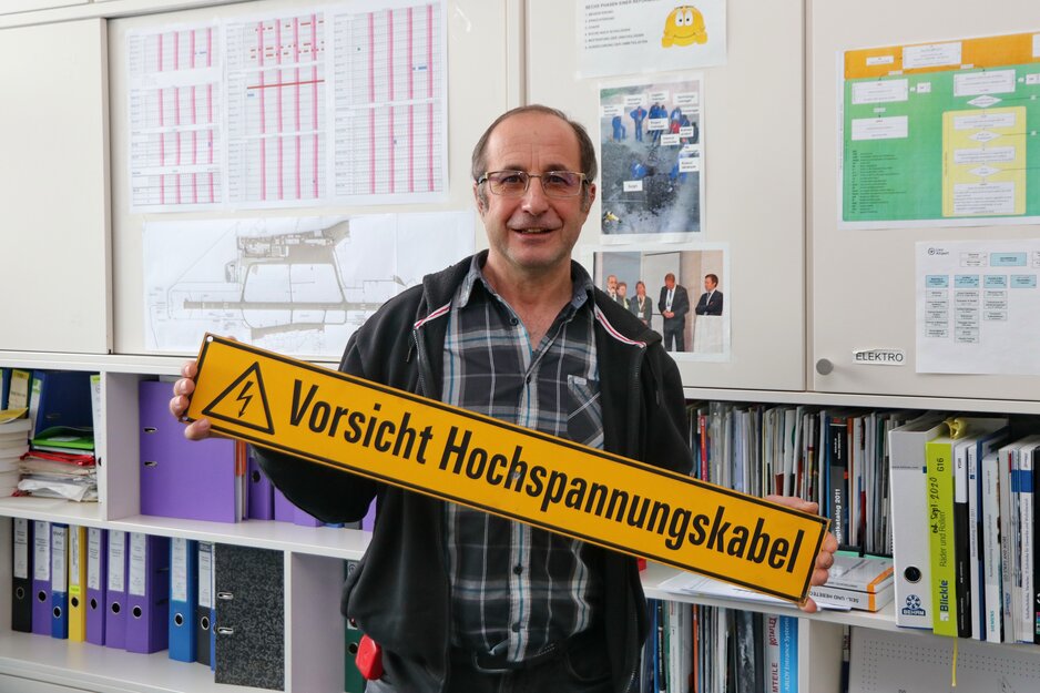 Mitarbeiter mit Schild "Achtung Hochspannungskabel" in der Hand | © Linz Airport