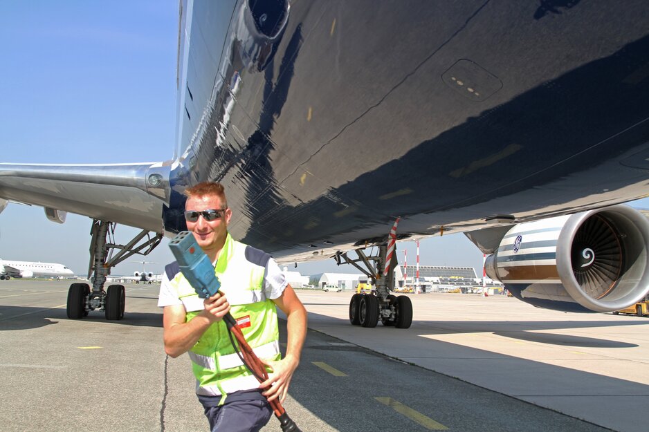 Vorfeldmitarbeiter mit Stromversorgungskabel des Ground Power Unit vor Flugzeug | © Linz Airport