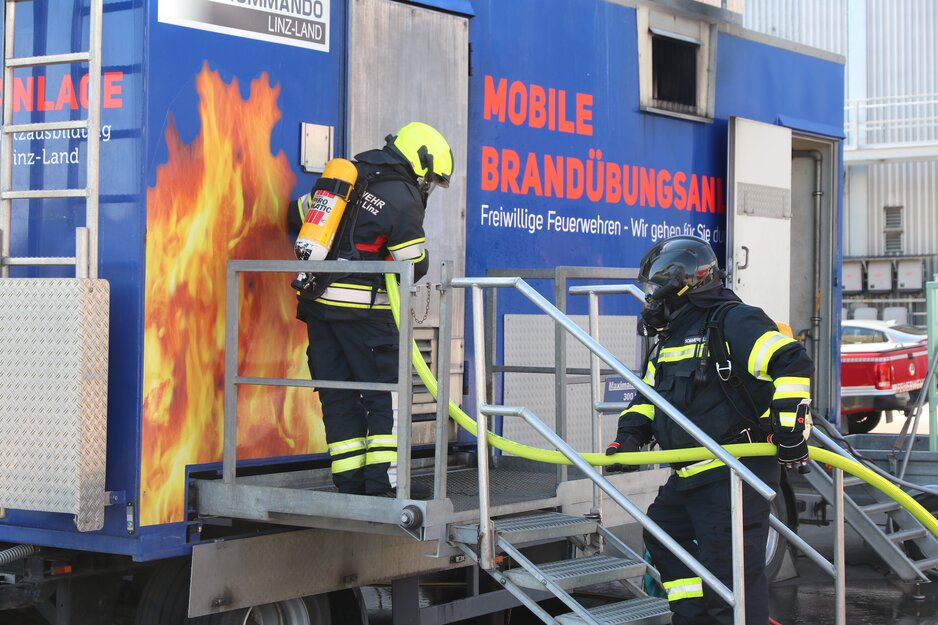 Zwei Feuerwehrleute in Schutzausrüstung beim Betreten der Heißübungsanlage | © Linz Airport