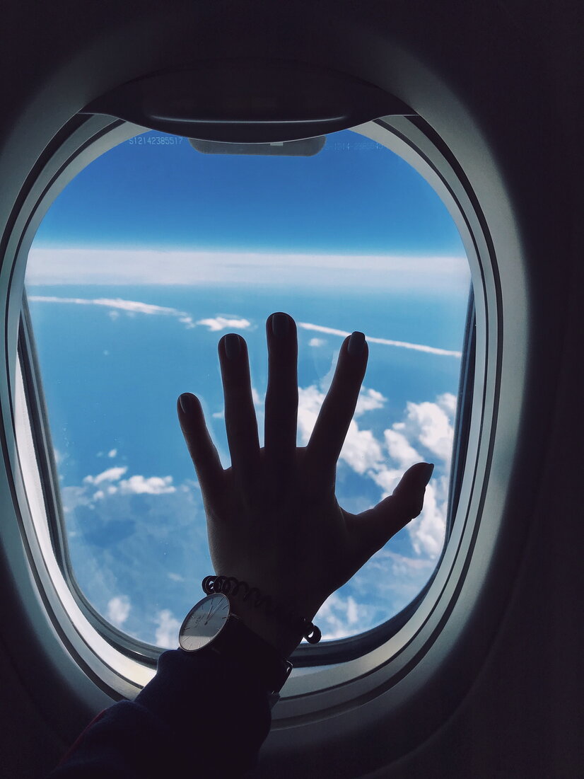 Hand auf Fensterscheibe im Flugzeug | © Jule Pexels