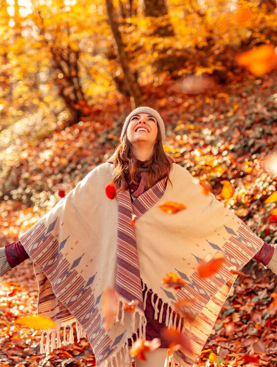 Glückliche junge Frau wirft bunte Herbstblätter im Wald in die Luft | © Envato Elements