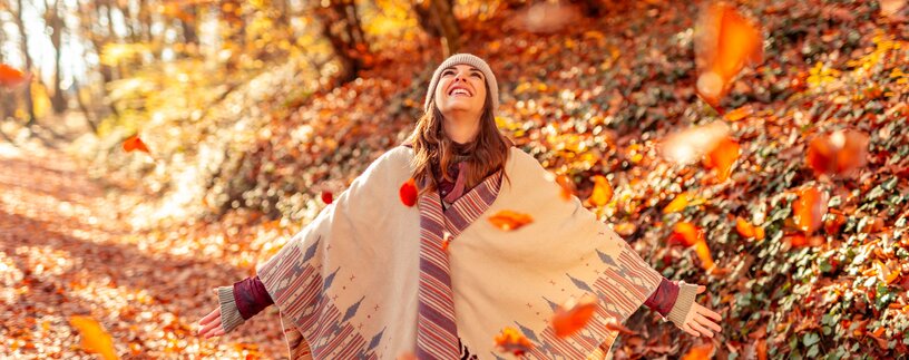 Glückliche junge Frau wirft bunte Herbstblätter im Wald in die Luft | © Envato Elements