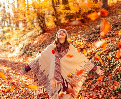 Glückliche junge Frau wirft bunte Herbstblätter im Wald in die Luft | © Envato Elements