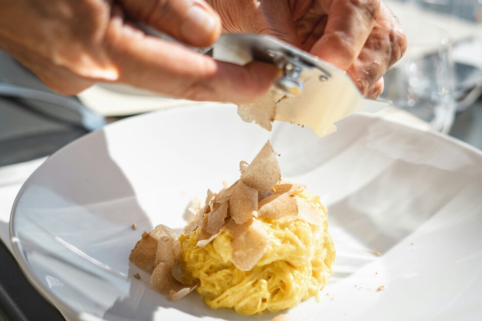 Parmesan wird über helle Nudeln gehobelt | © Unsplash