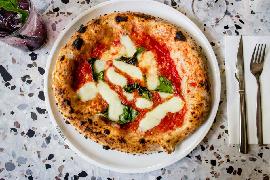 Tomaten-Mozarella-Pizza auf weißem Teller | © Unsplash