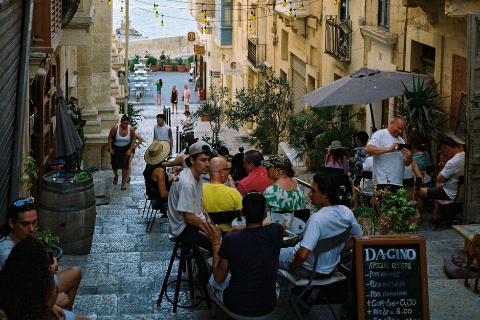 Taverne mit Gästen in kleiner Gasse mit Treppen | © Unsplash