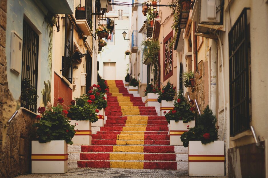Rot-gelb-rot gestrichene Treppe zwischen Häusern | © Unsplash