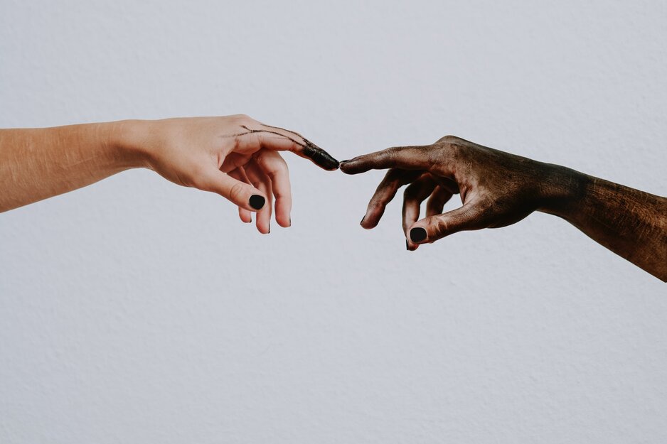 Eine weiße und eine dunkle Hand deren Zeigefinger sich berühren | © Lilartsy Pexels