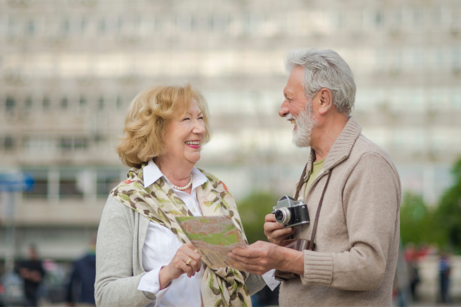 Älteres Paar mit Stadtplan und Kamera lächeln sich an | © Canvas