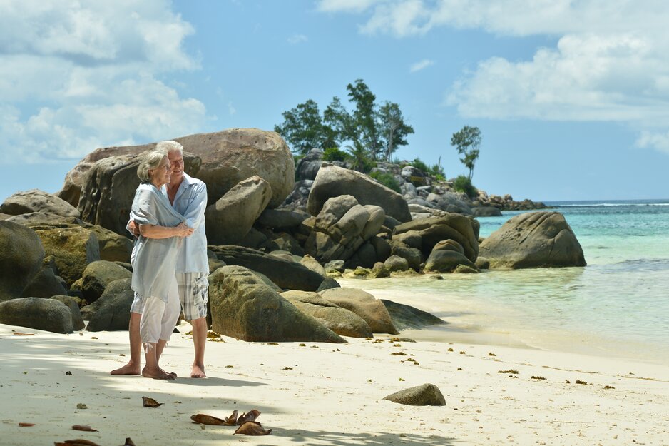 Älteres Paar steht sich umarmend am Strand | © Freepik