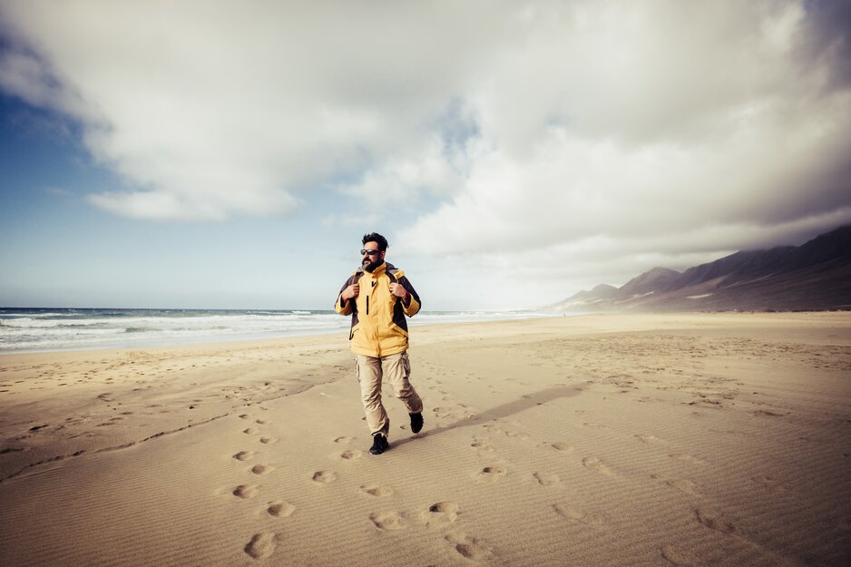 Mann mit Rucksack in windiger Bucht | © Envato Elements